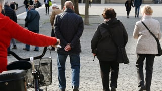 seniors che van a pe tras ina via d'ina citad