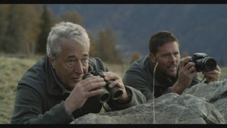Arturo Plozza e Livio Costa davos in crap cun perspectiv ed apparat da fotografar.