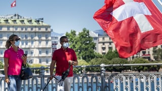 Duas persunas cun mascrina a la riva dal Lai da Genevra.
