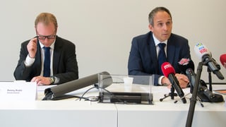 Il procuratur public ed il schef da la polizia davant ils microfons.