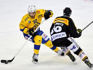 Raffaele Sannitz da Lugano (dre.) en cumbat per il puck cunter Noah Schneeberger da Tavau (san).