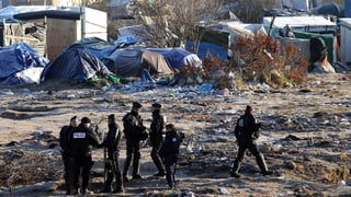 Policists franzos a l’ur dal champ da fugitivs Calais.