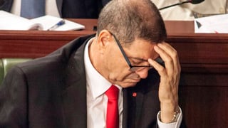 Habib Essid tegn il maun sin il frunt e guarda engiu - la foto è vegnida fatga curt avant il votum da confidanza dal parlament tunesian.