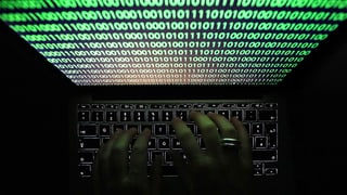 Mauns vid scriver in code d'attaca da cyber vid il laptop.