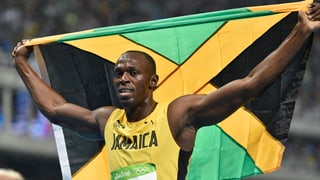 Usain Bolt cun la bandiera da la Jamaica suenter sia victoria sur 200 meters a Rio.