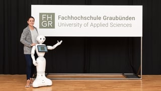 Ina studenta ha preschentà ensemen cun il roboter Pepper il Logo da la FH Grischun.