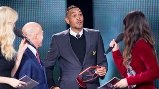 Il giugader da ballape Guillaume Hoarau cun ina distincziun enta maun.