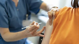 purtret d'ina dunna che survegn gist ina squitta dal vaccin da corona. 
