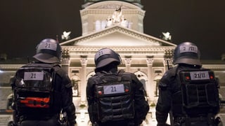polizists en mondura e chapellinas avant chasa federala