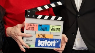 Dus mauns che tegnan in placat cun si Tatort.