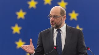 Martin Schulz tegn in pled, davosvart la bandiera da la UE.