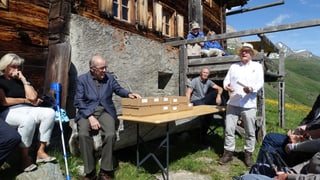 Philipp Egger da l'Uniun cuntrada cultivada Platta preschenta il nov cudesch, preschent vi da la maisa è era Martin Bundi, anteriur president dal Cussegl naziunal.