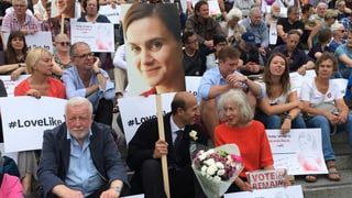 Il maletg mussa persunas cun fotografias e placats che sa regordan da Jo Cox
