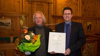 Il maister ortulan Klaus Oetjen e Christoph Hangartner, il president da l'uniun sa legran dal premi.