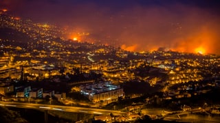 Vista sin la citad Funchal ch'è circumdada da flommas. 