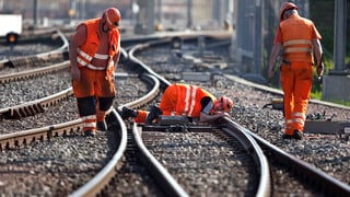 Trais persunas vid lavurar vid las rodaglias da tren.