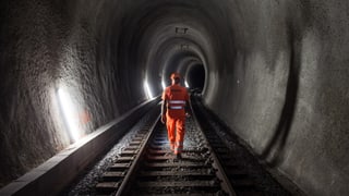 Purtret d'in um en mondura da lavur che va tras in tunnel. 