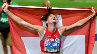 Purtret da Lea Sprunger che tegna ina bandiera svizra enta maun. 