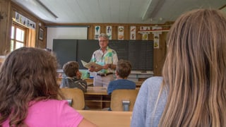 Il scolast davant che instruescha ina gruppa d’uffants. 