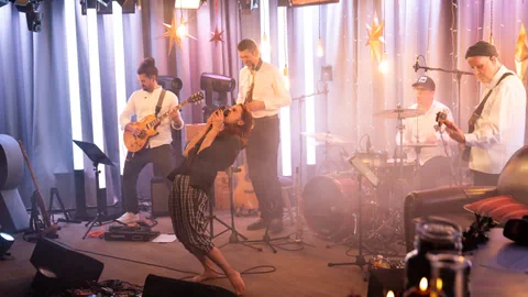 Band spielt live auf Bühne mit Sänger in energetischer Pose.