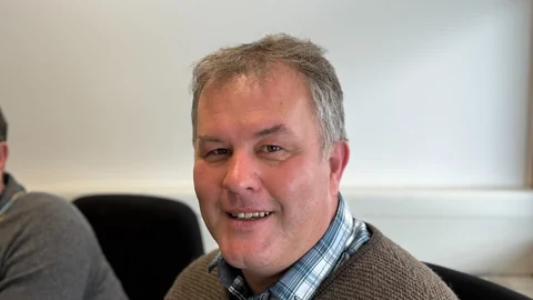 Ein Mann schaut in die Kamera.