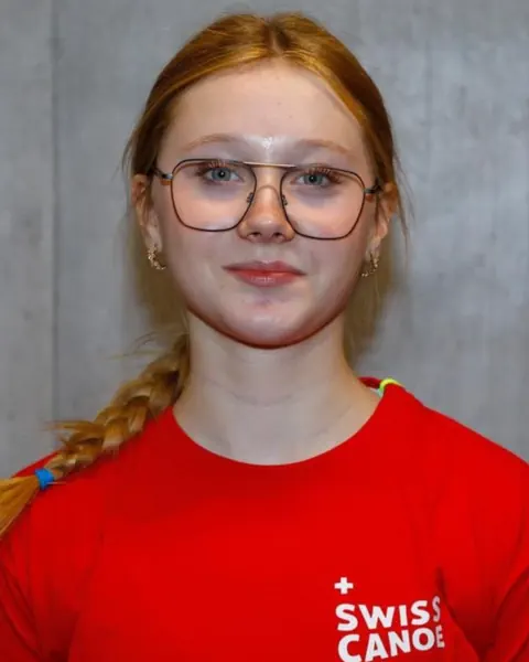 Mädchen mit Brille und rotem Swiss Canoe T-Shirt.