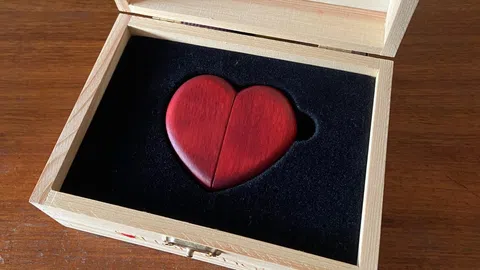 Rotes Herz aus Holz in einer Holzschachtel mit schwarzem Samteinlage.