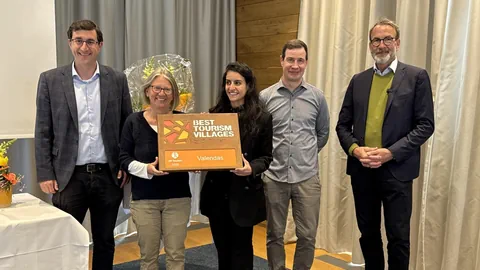 Fünf Personen präsentieren eine Auszeichnung mit der Aufschrift 'Best Tourism Villages Valendas.'