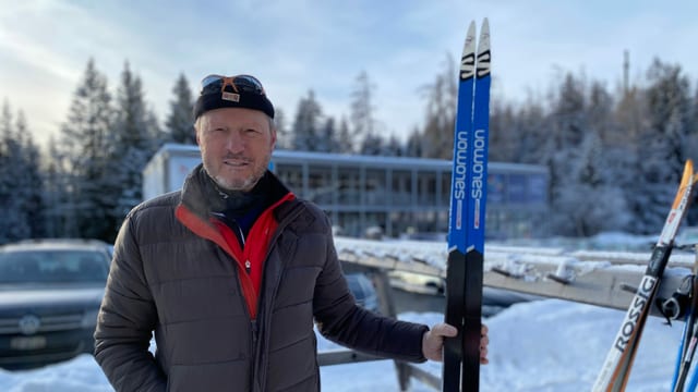 Ernst Orlik, scolast da passlung a Lai, cun in pèr skis da passlung en maun.