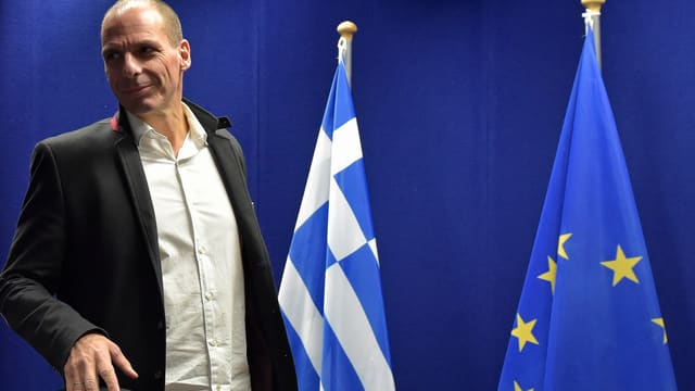 Yanis Varoufakis il minister da finanzas da la Grezia sper las bandieras da la Grezia e da l'UE
