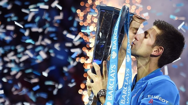 Il giugader da tennis Djokovic cun ses pocal dals ATP Tour Finals sunter batter Roger Federer a Londra, ils 22 da november 2015.