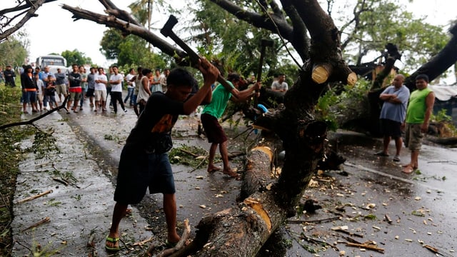 Abitants sin las Filippinas gidan sez a rumir ils fastizs da la devastaziun dal taifun.