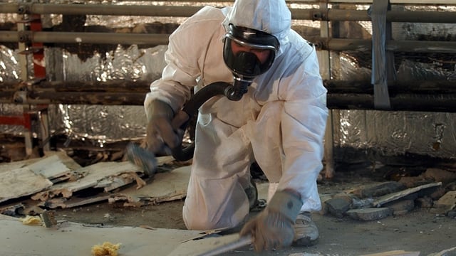 Lavurants che dismettan material che cuntegna asbest ston urgentamain purtar in vestgì da protecziun. 