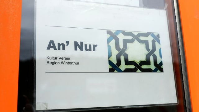 Ina tavla vi da l'isch d'entrada da la moschea An'Nur a Winterthur