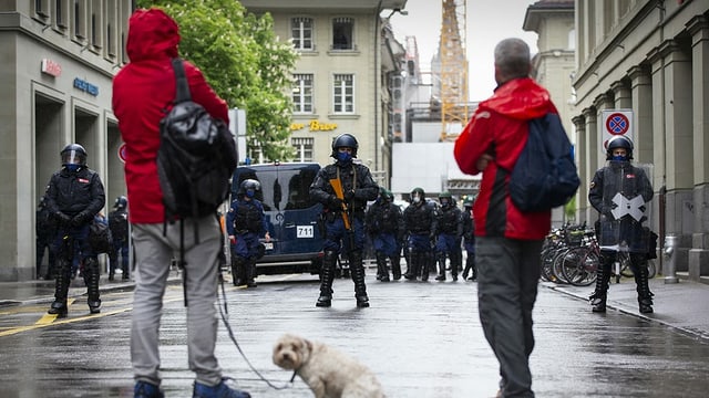Polizists bloccheschan la via datiers d'ina demonstraziun da corona a Berna.