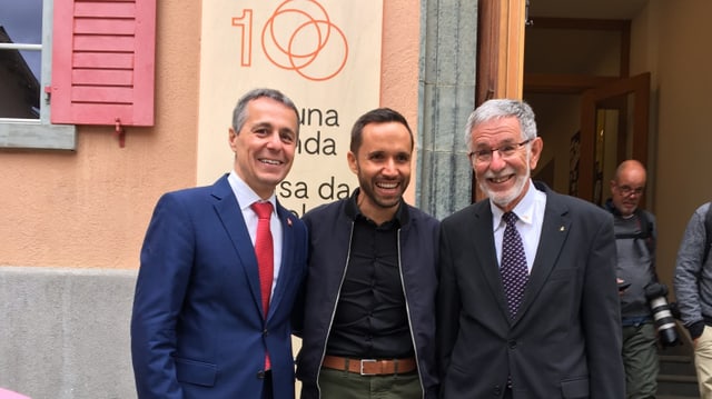 Ignazio Cassis, cusseglier federal, Mario Pacchioli, chantadur che fa part dal program e Johannes Flury, president da la Lia Rumantscha. Ignazio Cassis, cusseglier federal, Mario Pacchioli, chantadur che fa part dal program e Johannes Flury, president da la Lia Rumantscha.