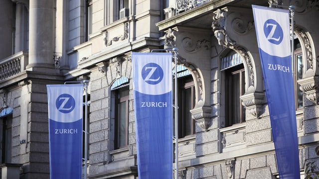 Bandieras pendan avant la sedia principala da l’assicuranza Zurich. 