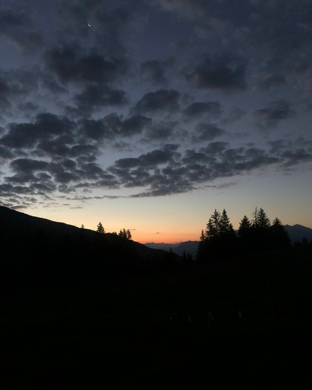 purtret d'ina bella cuntrada cun la rendida dal sulegl.