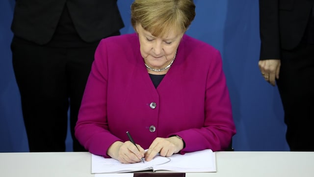 Angela Merkel suttascriva la cunvegna da coaliziun. 