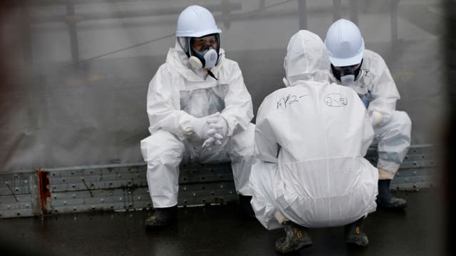 Lavurers en vestgids protectivs a Fukushima.