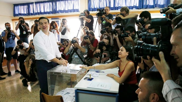 Il primminister grec en in local da votaziun, el metta ses cedel da vuschar en l'urna