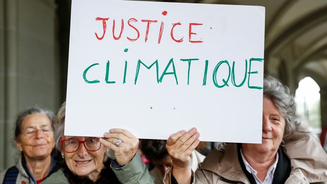 Senioras tegnan in chartun cun scret si «Justice climatique»