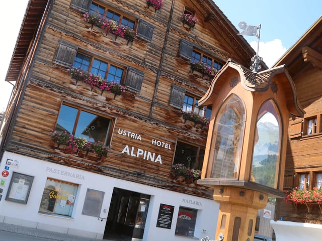 La chasa hotel Alpina en lain, e devon la funtauna da Nossadunna.	
