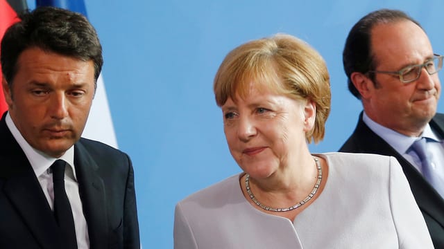 Matteo Renzi guarda preoccupà, Angela Merkel ria e François Hollande guarda or dal purtret.