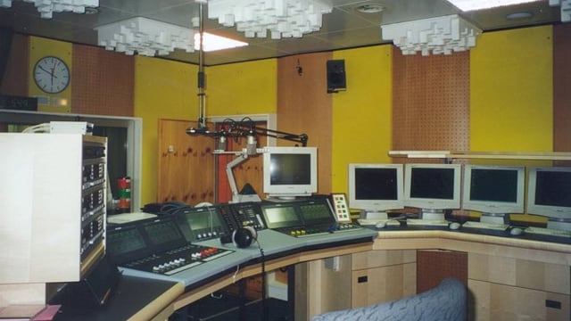 Studio da radio da l'onn 2000 cun ina massa computers e technica.