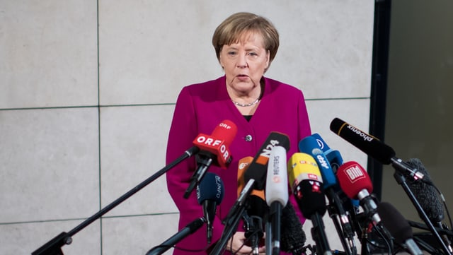 Angela Merkel avant microfons.