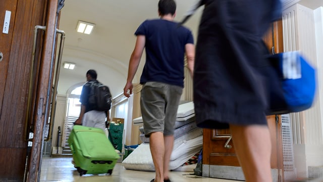 Requirents d’asil arrivan en in center d’asil a Genevra.