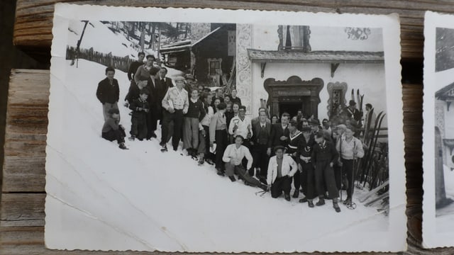 Fotografia da gruppa veglia. Umens ed uffants cun skis. 