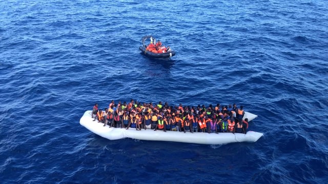 Ina bartga cun fugitivs en la Mar Mediterana. 