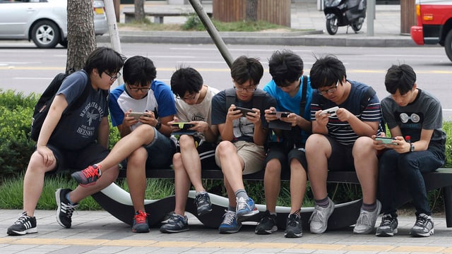 Giuvens en la Corea dal sid vi da lur smartphones.